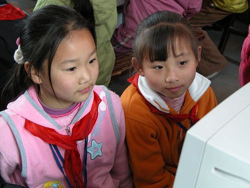 two kids looking at a computer screen